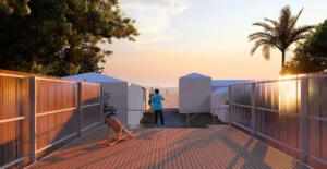 Minimalistische Dachterrasse aus Holzdeck in der Abenddämmerung mit schützenden Polycarbonat-Brüstungen und freiem Blick auf das Meer.