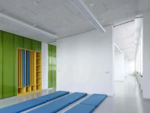 Heller, minimalistischer Spielraum mit blauen Bodenmatten, strukturierten Akustikdeckenplatten, maßgefertigten gelben Einbaumöbeln und grünen Akzenten aus transluzentem Glas.